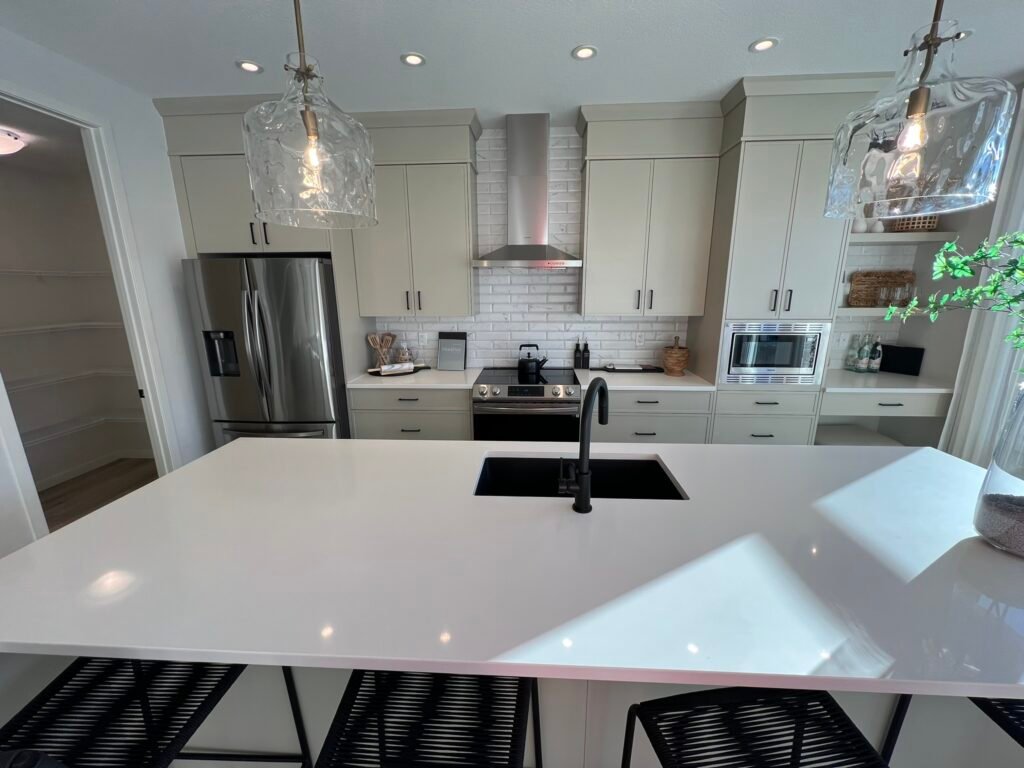 Bright white kitchen with full-height upper cabinets and quartz countertop – custom installation by Coldii Inc. in Calgary